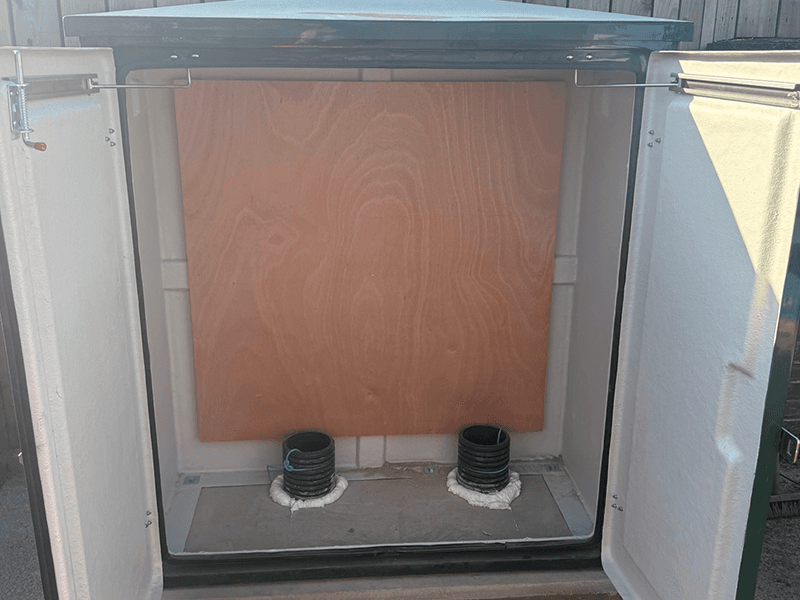 School drainage access cabinet revealing aged pipework